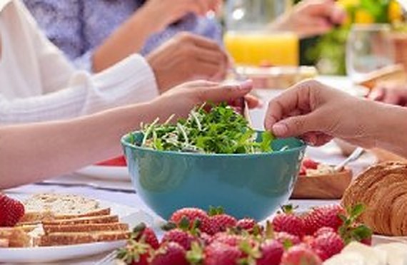 Friends sharing a fresh salad at the table